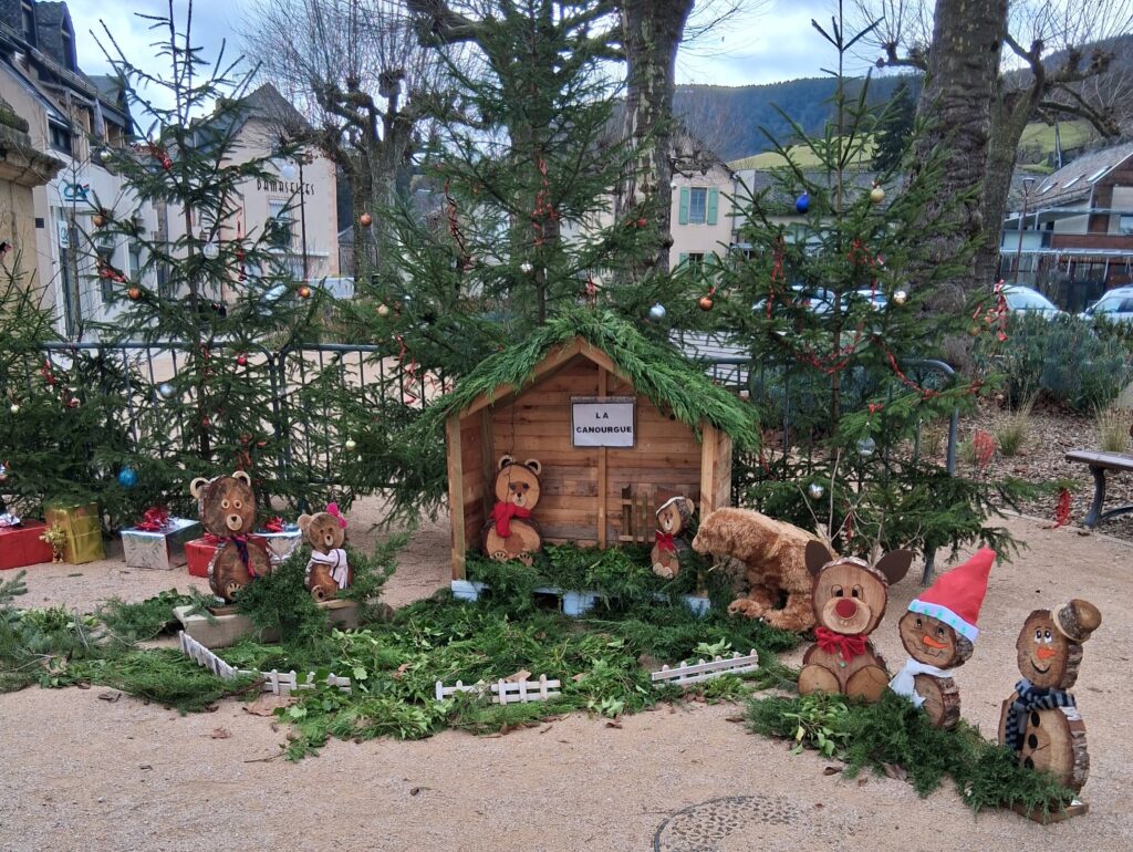 Petit chalet en bois évoquant la gare de La Canourgue avec des ours en bois