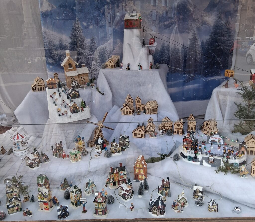 village de chalets miniatures avec patinoire, téléphérique sous la neige